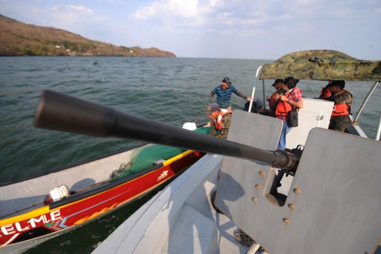 Soldados hondureños de una patrullera artillada conversan con pescadores artesanales con base en Amapala, en el golfo de Fonseca, cuyas aguas comparten Honduras, El Salvador y Nicaragua. Foto Orlando Sierra (AFP)