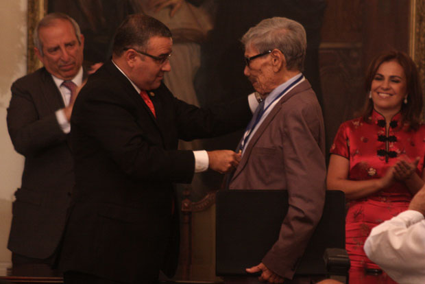El presidente de la república, Mauricio Funes, entregó al pintor Carlos Cañas el Premio Nacional de Cultura 2012. Al fondo, a la izquierda, el presidente de la Asamblea Legislativa, Sigfrido Reyes, y a la derecha, la primera dama Vanda Pignato.