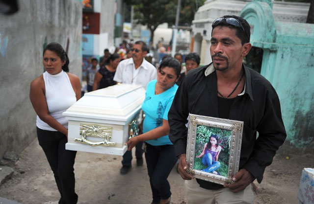 Noé Martínez, padre Iris Martínez, carga una foto de su hija durante el funeral en el Cementerio Municipal de Soyapango el 12 de marzo 2013. Foto AFP﻿  