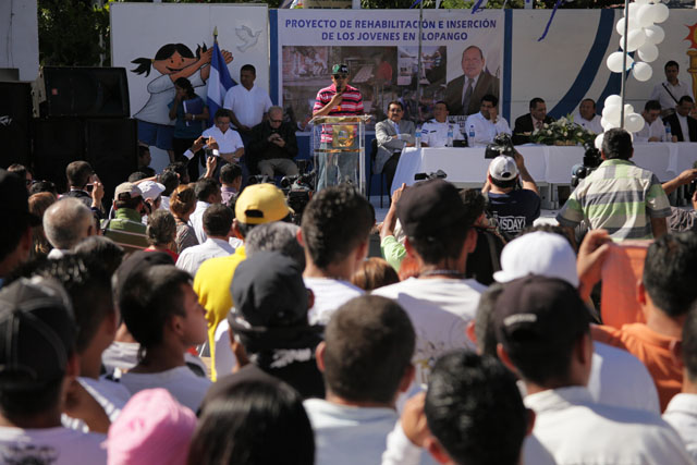 Un pandillero del Barrio 18 d un discurso durante el acto oficial de declaración de Ilopango como Municipio Libre de Violencia. A la derecha, en la mesa, escuchaba Douglas Moreno.