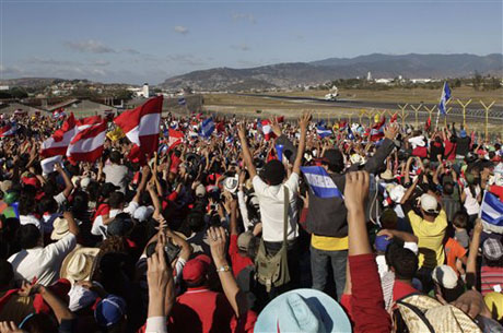 Simpatizantes de Manuel Zelaya se aglomeran en el aeropuerto mientras el avión que transporta al derrocado presidente despega rumbo a República Dominicana. Foto AP