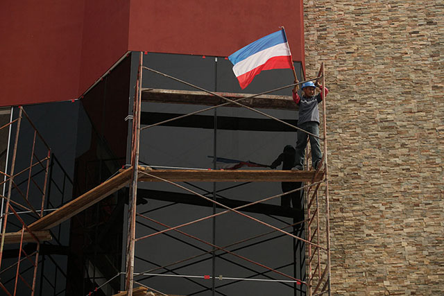 Martes 11 de marzo. Un obrero de la construcción de un edificio en la Calle del Mirador ve pasar la manifestación desde un andamio y ondeando una bandera del partido Arena.