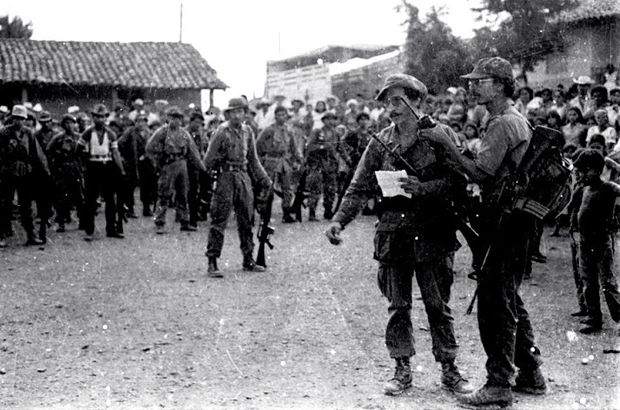 Miguel Huezo Mixco, radio en mano junto al cmte. Germán Serrano, durante transmisión de Radio Farabundo Martí durante la entrega de prisioneros del ejército a la Cruz Roja Internacional, en La Laguna Chalatenango. / Archivo de Miguel Huezo Mixco.