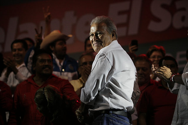 Salvador Sánchez Cerén ayuda a su esposa para sentarse durante la celebración del FMLN en la plaza Masferrer el 9 de marzo de 2014.