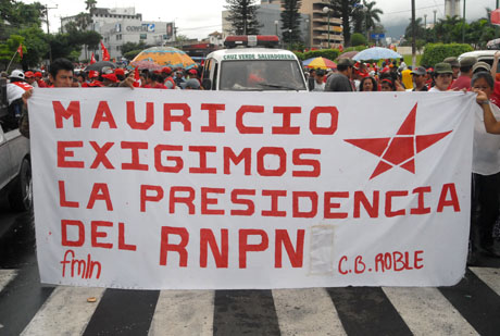 Un grupo de efemelenistas de San Antonio Abad, San Salvador, portan una manta durante la marcha del Primero de Mayo. Foto Mauro Arias