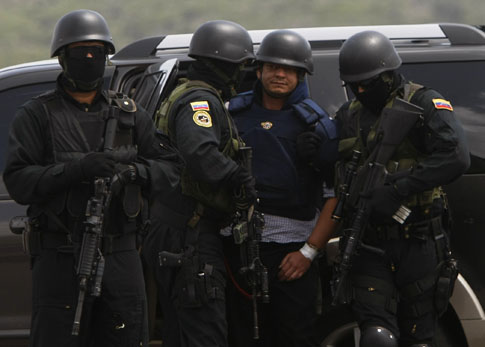 El salvadoreño Francisco Chávez Abarca, centro, es escoltado por agentes de la policía secreta venezolana en el aeropuerto Simón Bolívar de Caracas. Foto AP