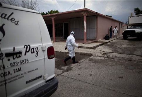 Un trabajador camina al lado de la funeraria donde se encuentra los 72 cadáveres de migrantes asesinados supuestamente el cartel de Los Zetas en San Fernando, Tamaulipas, a unos 160 kilómetros de la frontera con Estados Unidos. Foto AP