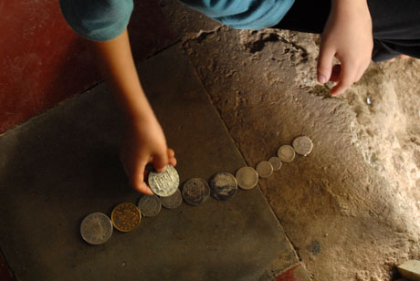 Uno de los hijos del campesino que descubrió la botija juega con las monedas que su padre guardó como recuerdo.