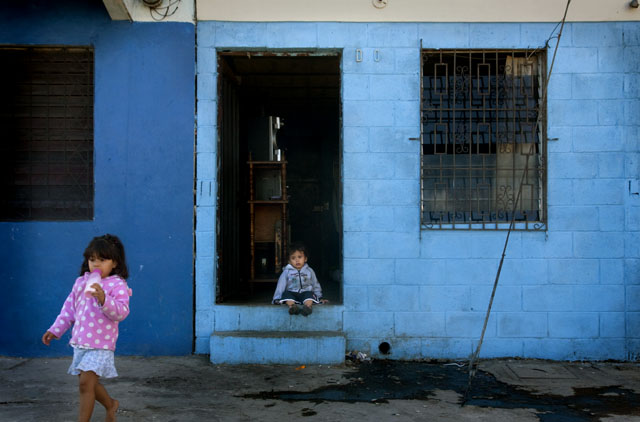 Ade, de un año y medio y Saraí de 2, dos de los hijos que dejo Karen Yamileth, en la entrada de su casa en la comunidad Trujillo al sur del Mercado Central de San Salvador. La casa se las cedio el padre de Anthony Montoya acompañante de vida y padre de los 3 hijos de Karen Yamileth.