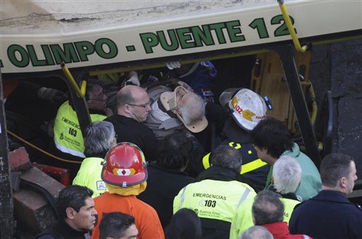 Un pasajero herido es sacado de un tren después de que un autobús cruzó las vías del ferrocarril suburbano en Buenos Aires, el martes 13 de septiembre de 2011.