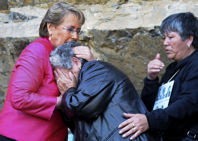 Michelle Bachelet (izquierda) trata de consolar a una familiar de un desaparecido durante la dictadura de Augusto Pinochet. Foto archivo El Faro.