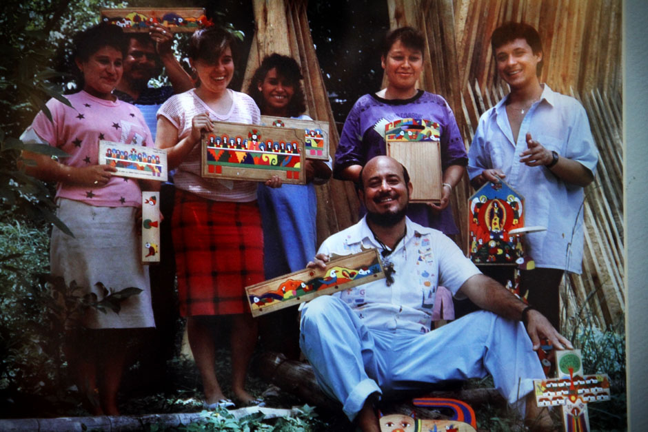 Foto de Fernando Llort mostrando los productos del taller La semilla de Dios con pobladores de La Palma, Chalatenango.﻿ / Foto cortesía de la Familia Llort.