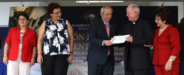 Sigfrido Reyes le entraga el certificado de donación al representante de una de las 22 organizaciones que se vieron beneficiadas este jueves. Entre estas no solo estaban organizaciones privadas, sino también estatales como el Hospital Rosales. Foto: Asamblea Legislativa