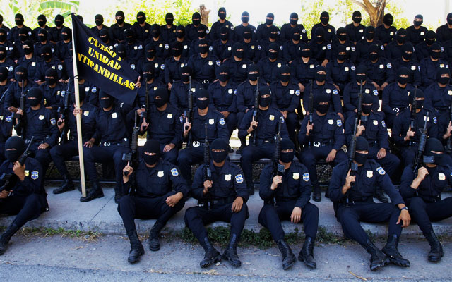 Rostros cubiertos y armas largas durante la presentación el pasado 9 de febrero ante los medios de comunicación de la Unidad Antipandillas de la Policía Nacional Civil. Foto Roberto Valencia﻿" /></div> <figcaption class=