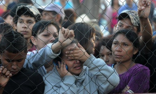 Parientes de reos de la cárcel de Camayagua, Honduras, esperan noticias en el cerco perimetral. Fotos AFP
