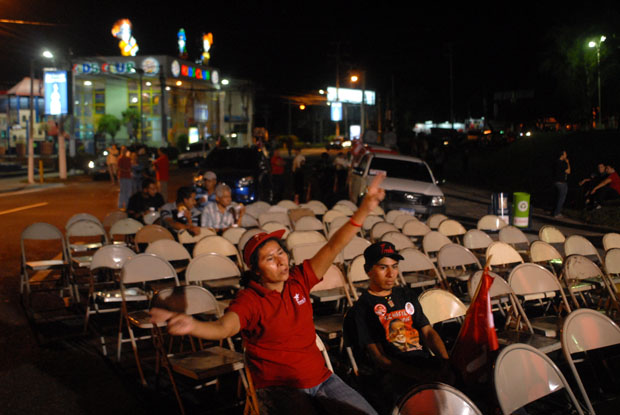 Una efemelenista corea solitaria la canción Casas de cartón del grupo venezolano Los Guaraguao en el redondel Masferrer de San Salvador. El FMLN planificó celebrar en este lugar los resultados de las elecciones.