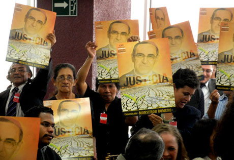 Miembros de la Concertación Monseñor Romero, invitados al evento en el aeropuerto, sacaron sus pancartas en busqueda de justicia. Foto Mauro Arias