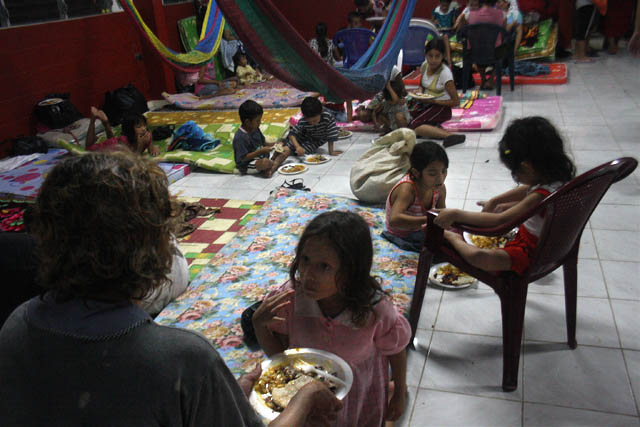 Balbina Vásquez da comida a su hija Karla García, de 7 años, en el refugio de El Zamorano, en el Bajo Lempa
