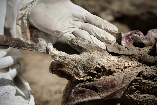 Israel Ticas en el proceso de pulir un cadáver, utilizando un instrumento que le sirve para desmoronar la tierra de los cuerpos.