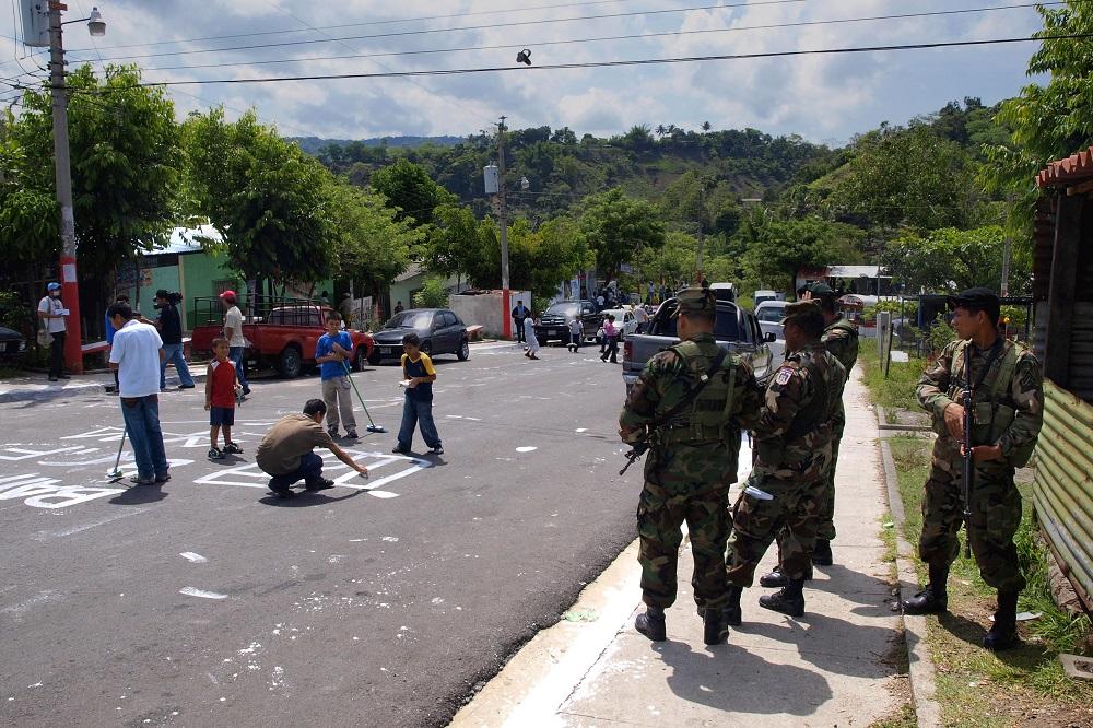Un grupo de militares observa con recelo los juegos de unos niños durante una actividad de la oenegé Fútbol Forever. Foto Roberto Valencia.