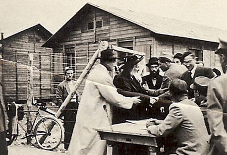 Imagen difundida por el Museo Estadounidense del Holocausto que muestra al rabino Satmar, tercero por la izquierda, con George Mantello, en abrigo blanco, discutiendo con guardas fronterizos suizos la entrada del rabino a Suiza el 7 de diciembre de 1944. (Foto AP/USHMM)