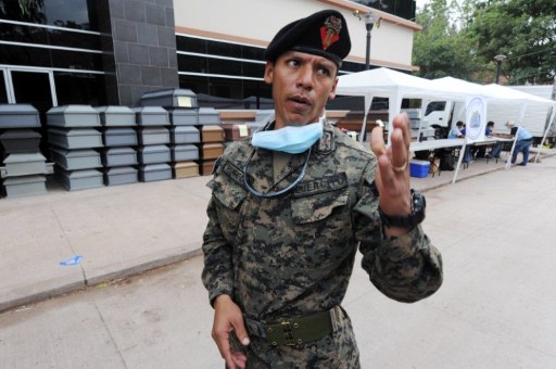 Un militar custodia ataudes donados antes de ser repartidos a los parientes de los fallecidos en Tegucigalpa. Foto AFP