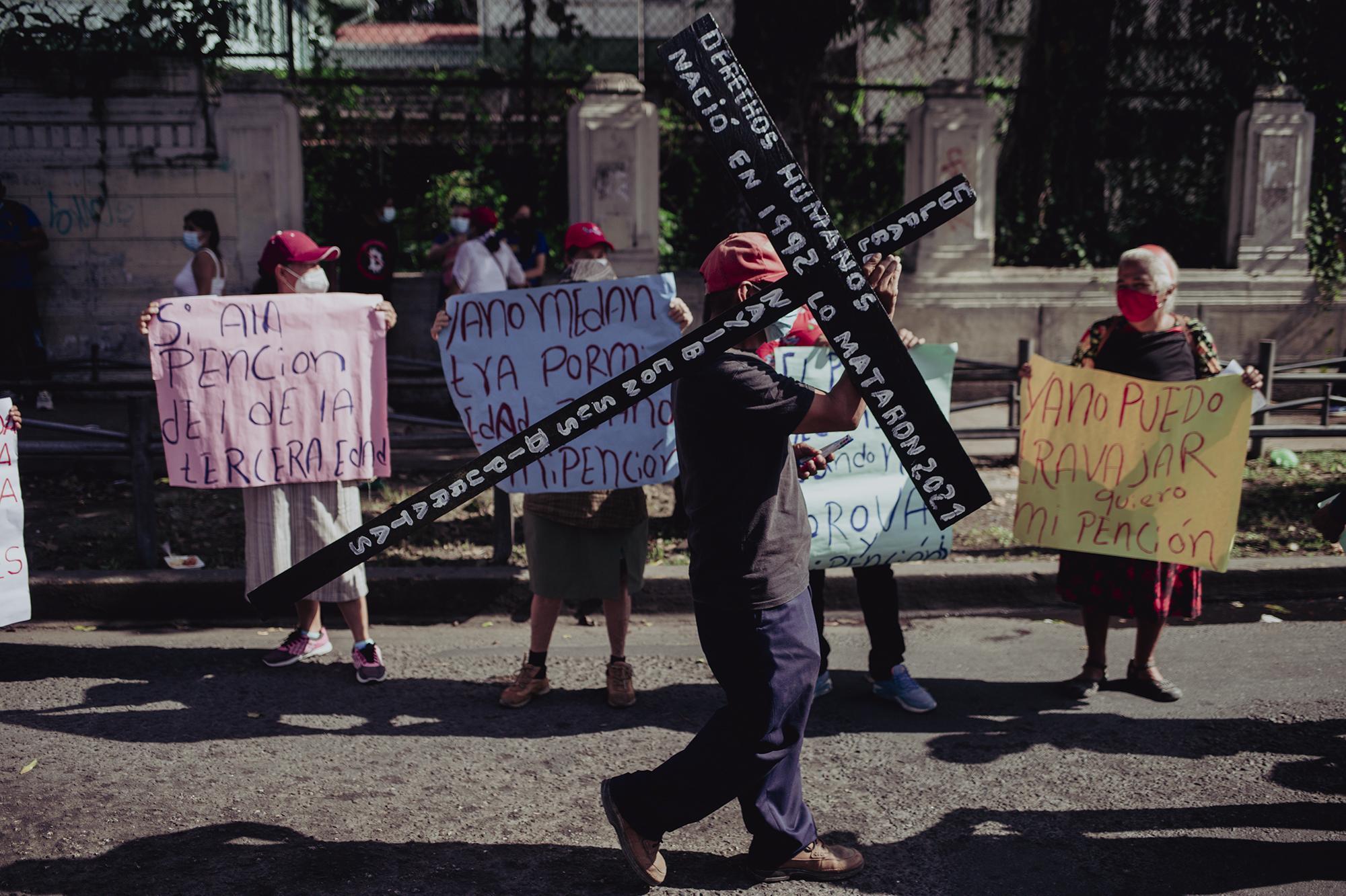 Juan Soledad carried a cross that said: “Human rights were born in 1992 and they were killed in 2021.” The first year referred to the Peace Accords that ended the 12-year-armed conflict in El Salvador.