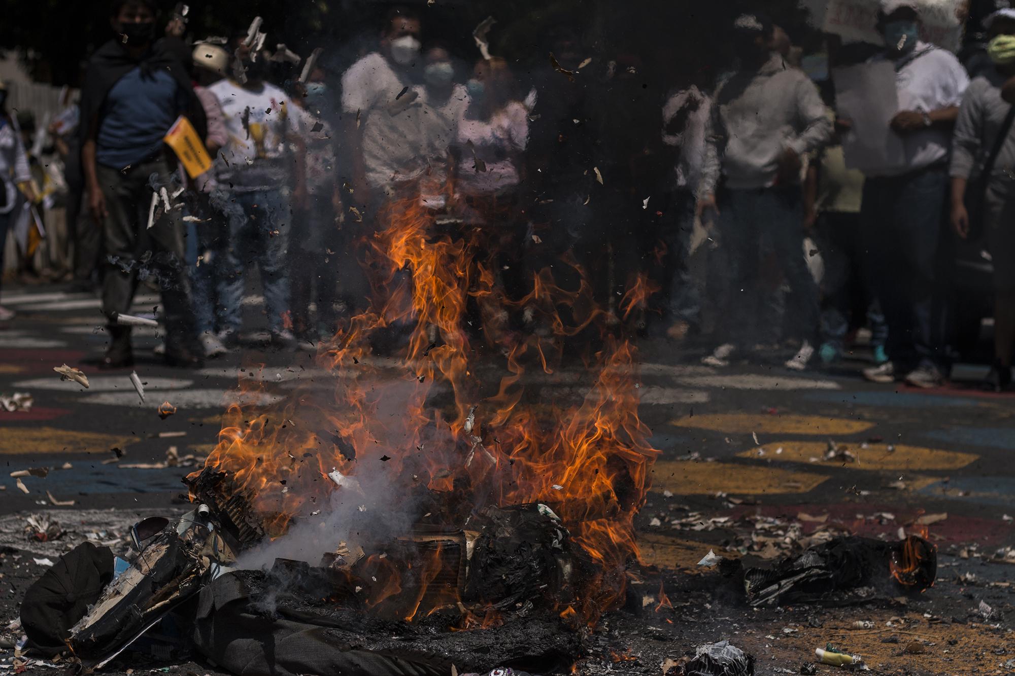 Al final de la marcha, un grupo de ciudadanos prendió fuego a un muñeco de trapo con la figura del presidente Bukele, que se burló de la marcha a través de sus redes sociales. Foto de El Faro: Víctor Peña. 